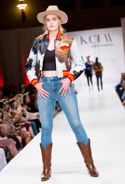 Goldbar Limited model wearing the tri-colored cowhide print Scout varsity jacket, on the runway at KCFW (KC Fashion Week)